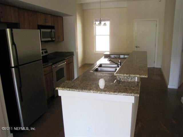 1661 Riverside Avenue, Unit 203 Jacksonville, FL 32204 - Photo 4 of 11 a kitchen with a refrigerator a stove a sink and a window