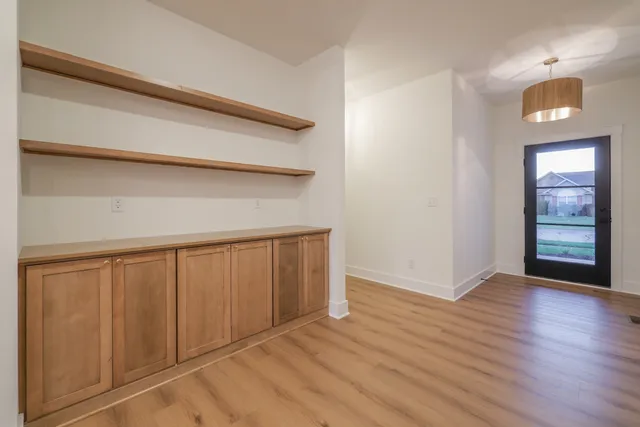 a view of an empty room with wooden floor