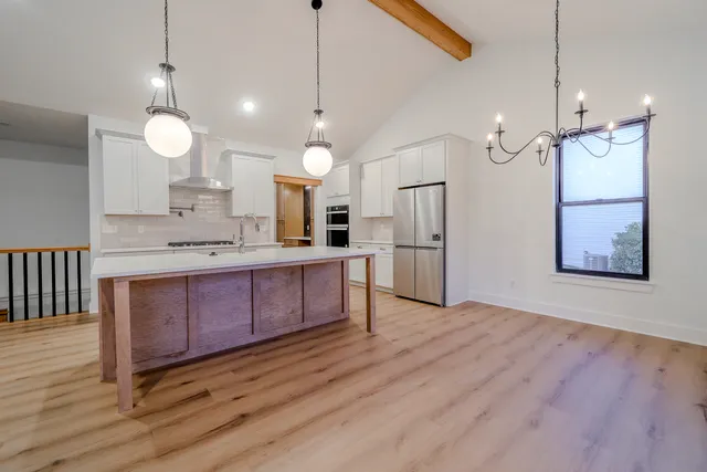 a large kitchen with stainless steel appliances kitchen island a large island in the center and wooden floors