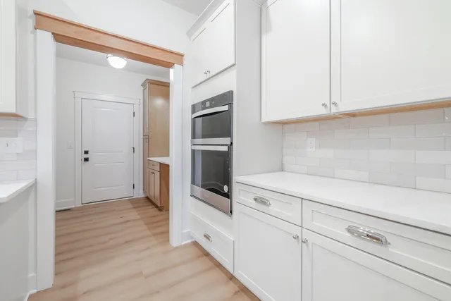 a kitchen with white cabinets and stainless steel appliances