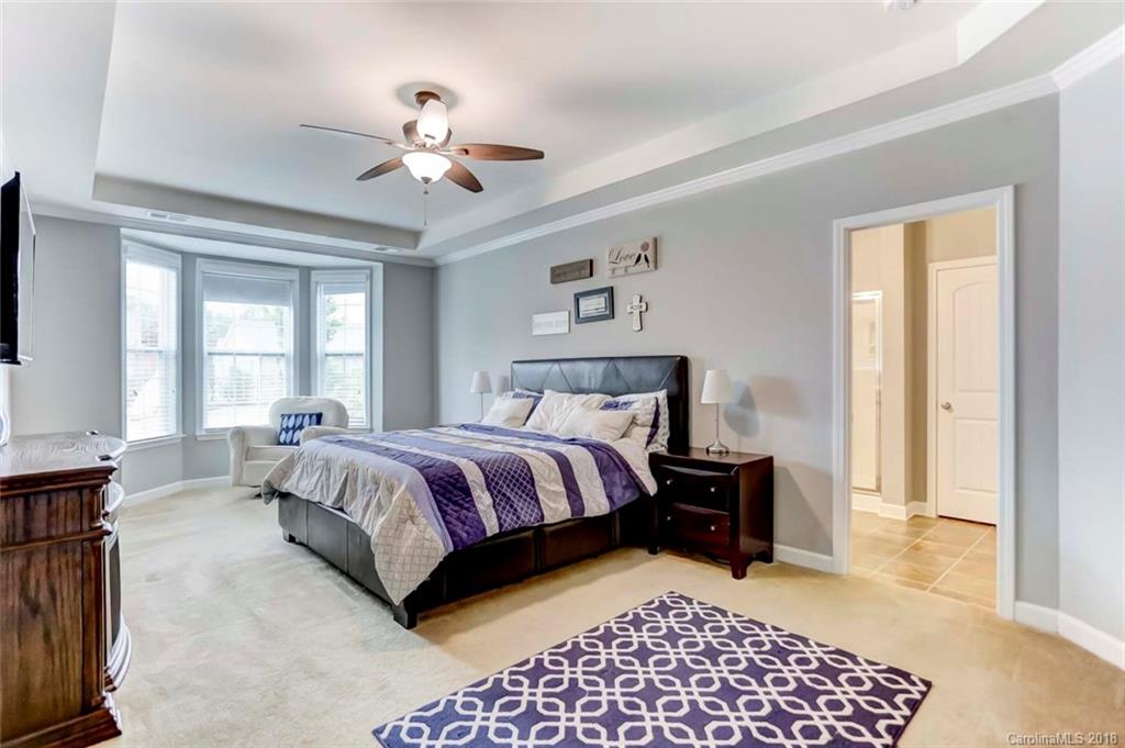 516 Rosemary Lane Fort Mill, SC 29708 - Photo 16 of 36 a spacious bedroom with a bed and a chandelier