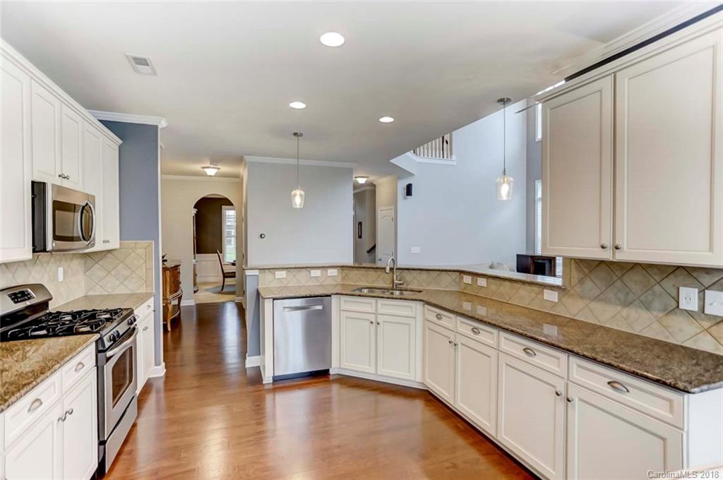 516 Rosemary Lane Fort Mill, SC 29708 - Photo 9 of 36 a large kitchen with stainless steel appliances granite countertop a lot of counter space and wooden floor