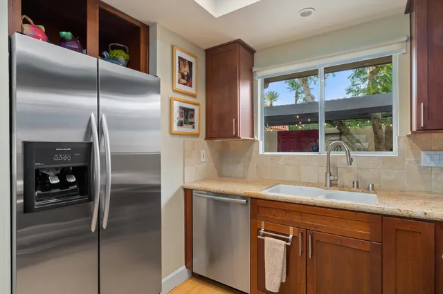 a kitchen with stainless steel appliances granite countertop a refrigerator and a sink
