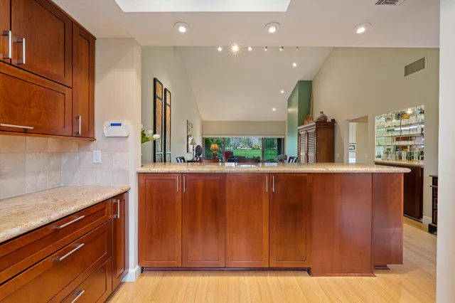 a kitchen with kitchen island granite countertop wooden cabinets and sink