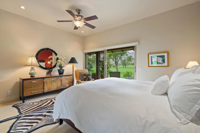 a bedroom with a bed a dresser next to a window