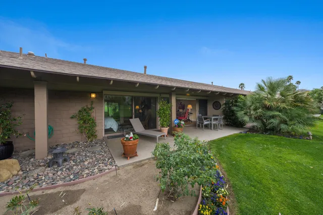 a view of a house with backyard sitting area and garden