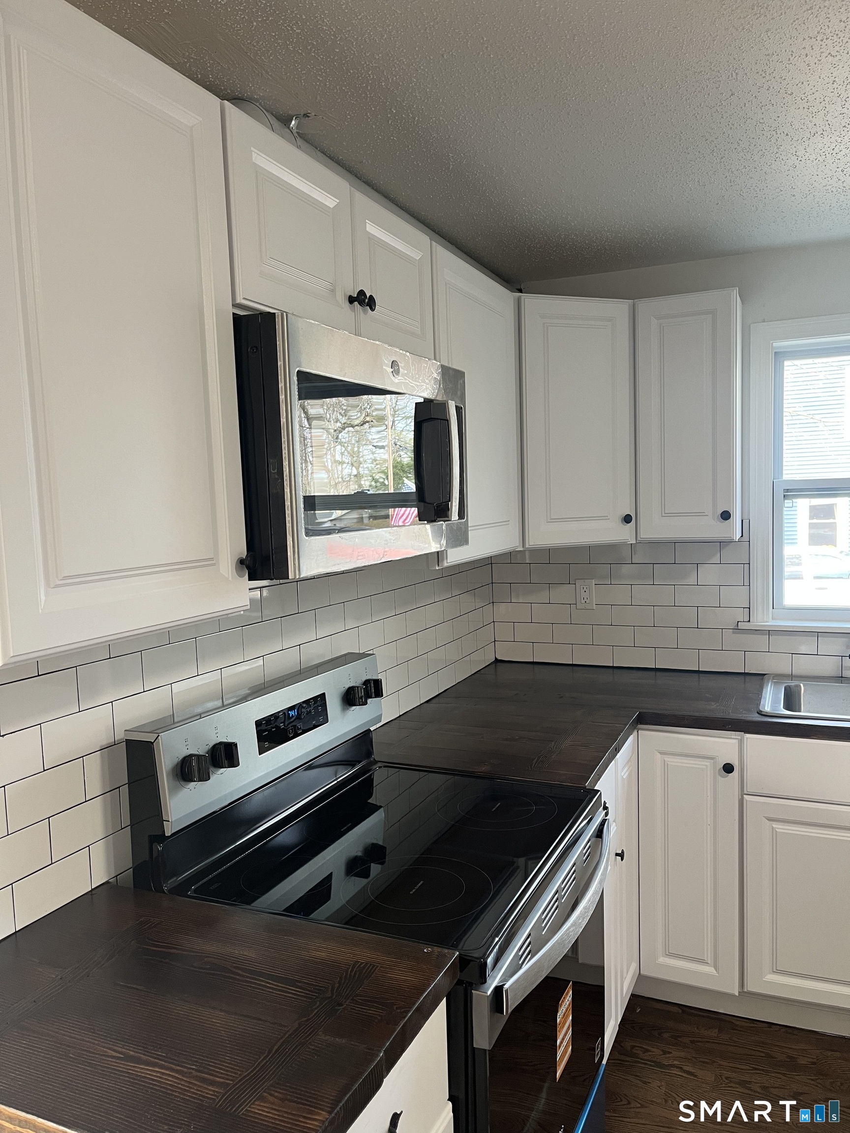 52 Pearl Street Manchester, CT 06040 - Photo 19 of 31 a kitchen with granite countertop a stove microwave and sink