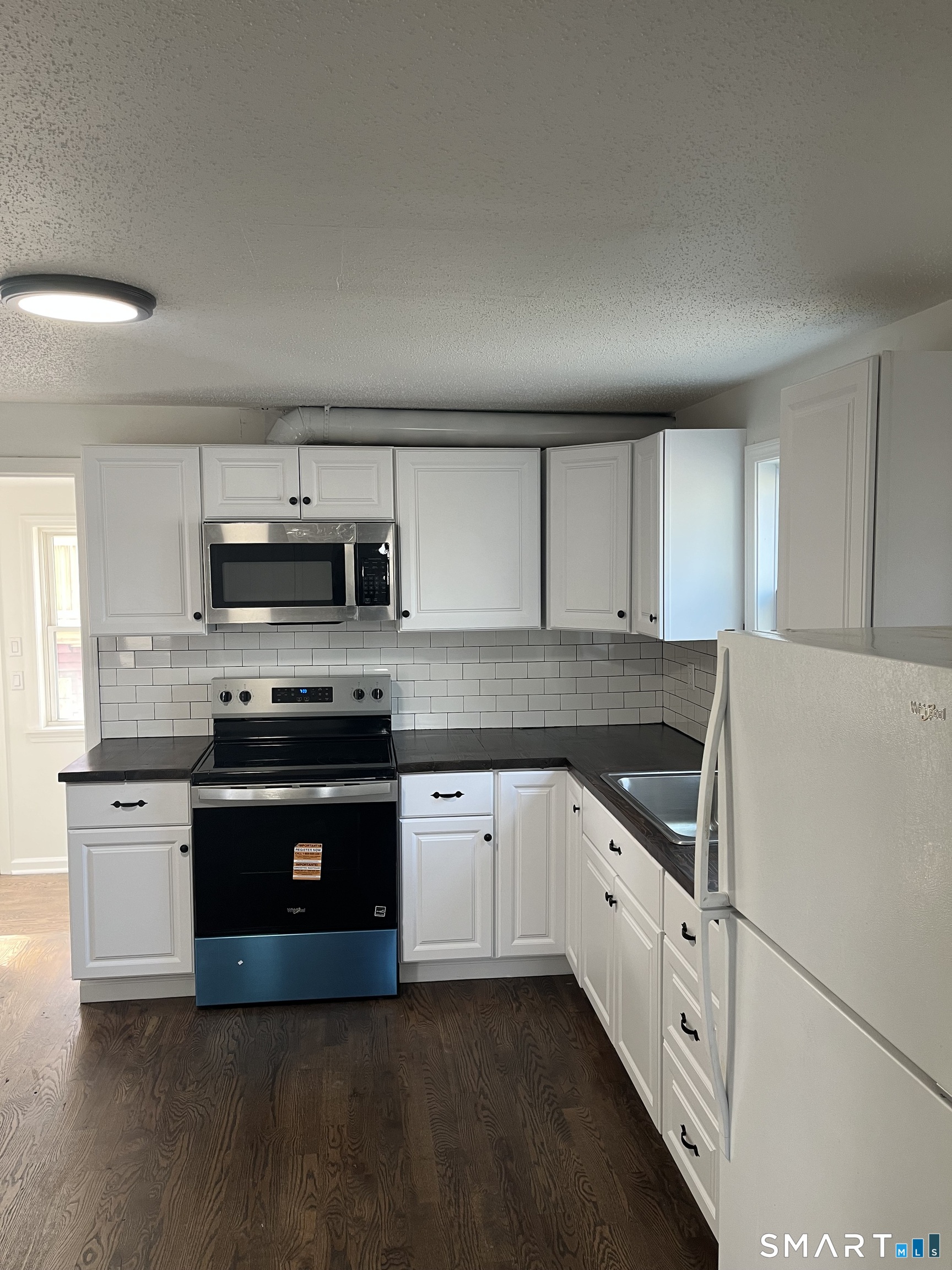 52 Pearl Street Manchester, CT 06040 - Photo 23 of 31 a kitchen with stainless steel appliances granite countertop a stove a sink and a microwave