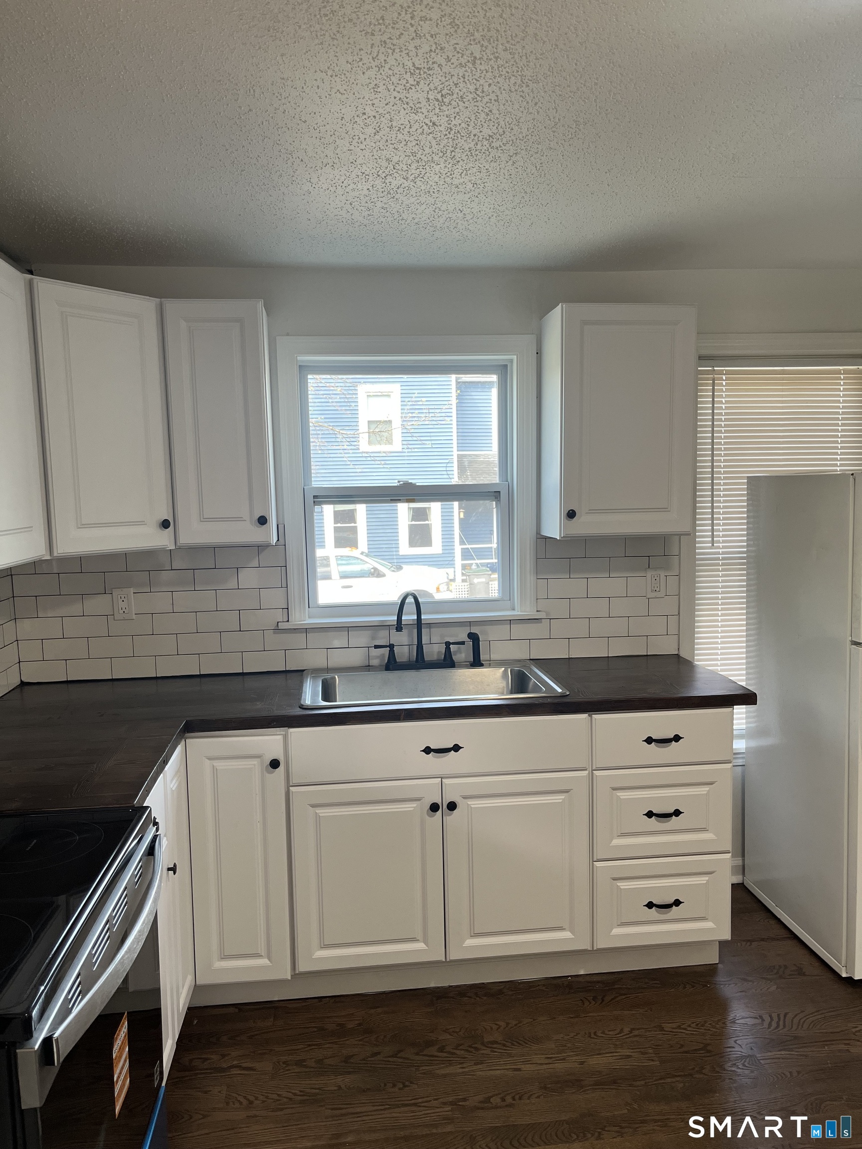 52 Pearl Street Manchester, CT 06040 - Photo 25 of 31 a kitchen with granite countertop white cabinets and a wooden floor