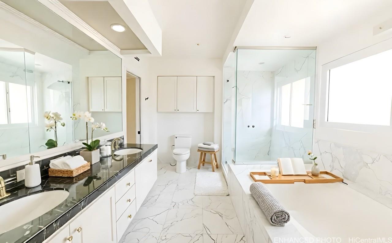 235 Portlock Road Honolulu, HI 96825 - Photo 13 of 21 a large white bathroom with a double vanity sink a mirror and a bathtub