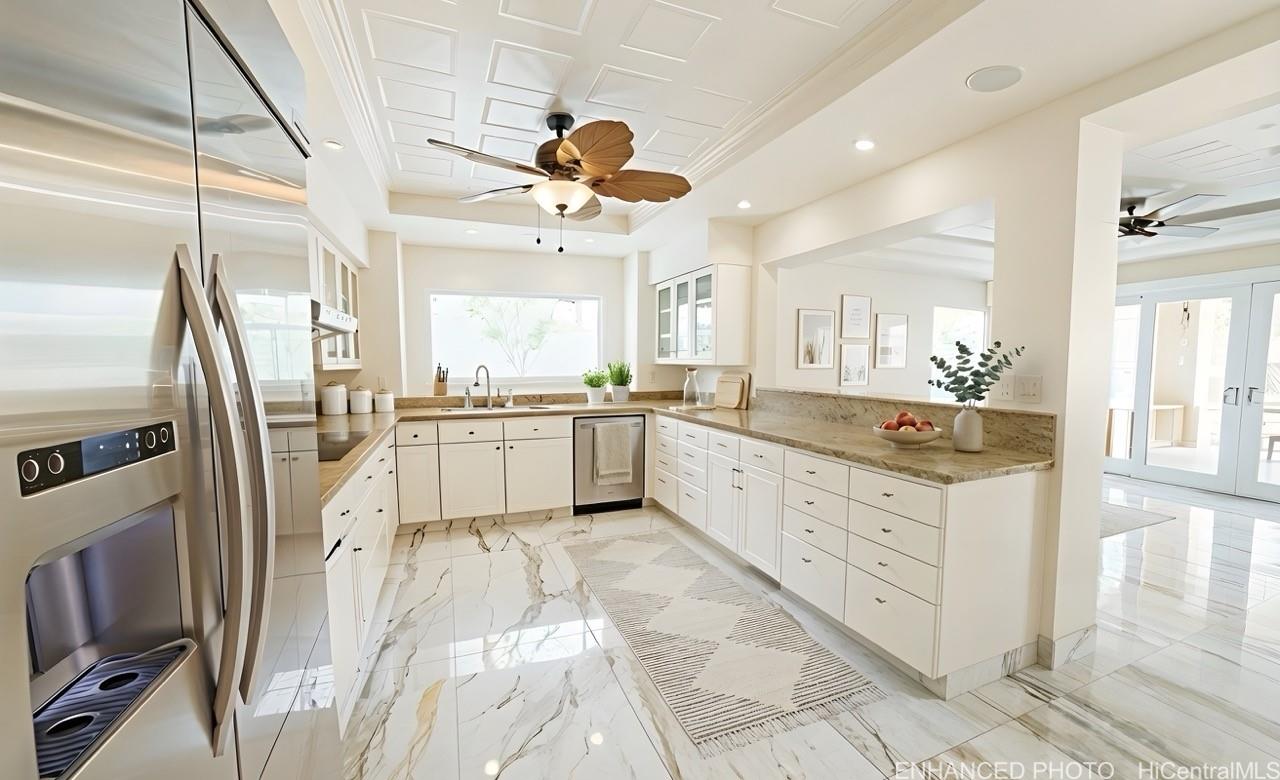 235 Portlock Road Honolulu, HI 96825 - Photo 8 of 21 a large kitchen with stainless steel appliances kitchen island granite countertop a refrigerator a sink a stove and white cabinets