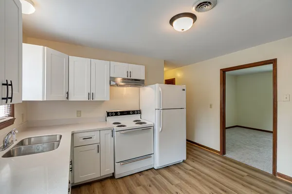 a kitchen with cabinets a refrigerator and a sink