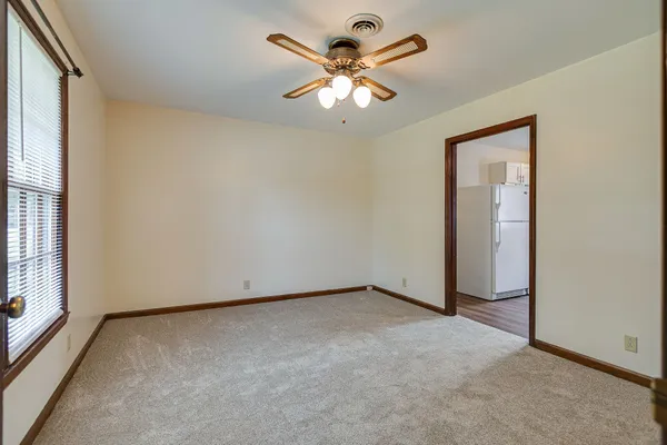 an empty room with closet and a chandelier fan