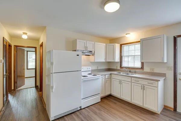 a kitchen with a sink a refrigerator a microwave and cabinets