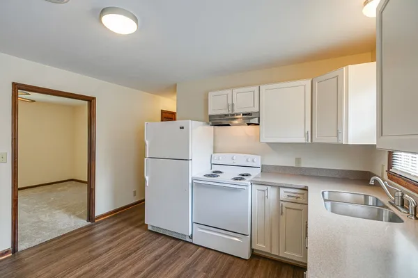 a kitchen with a refrigerator sink and cabinets
