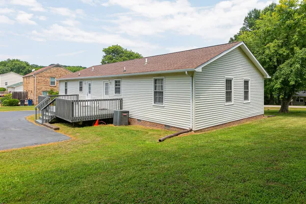 a view of a house with a yard and deck