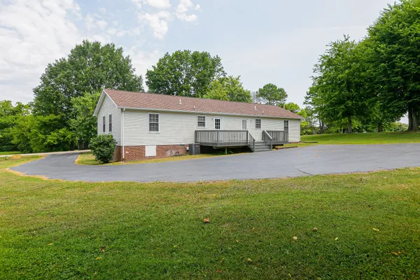 a view of a house with pool and a yard