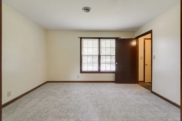an empty room with windows and closet