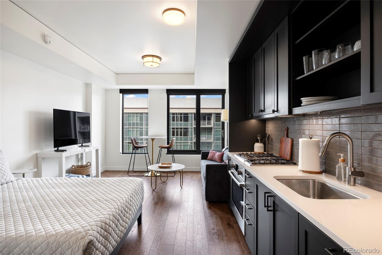 a large kitchen with stainless steel appliances a stove a sink a microwave a refrigerator and cabinets