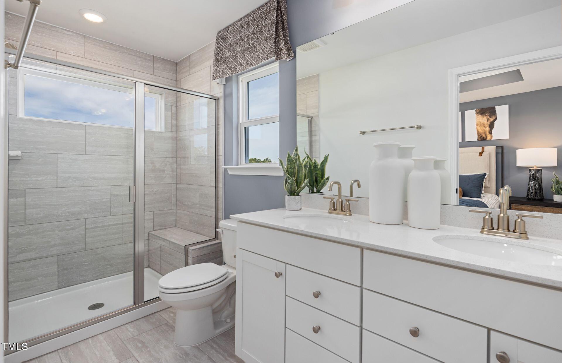 2783 Cassius Drive Apex, NC 27502 - Photo 11 of 18 a bathroom with a shower sink vanity mirror and toilet