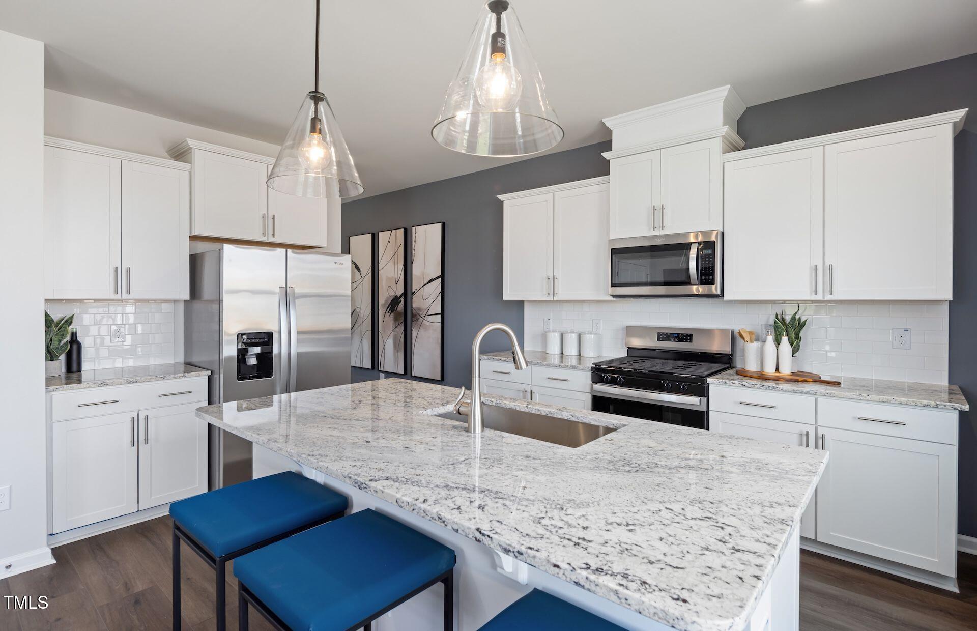 2783 Cassius Drive Apex, NC 27502 - Photo 4 of 18 a kitchen with stainless steel appliances granite countertop a sink refrigerator stove and microwave