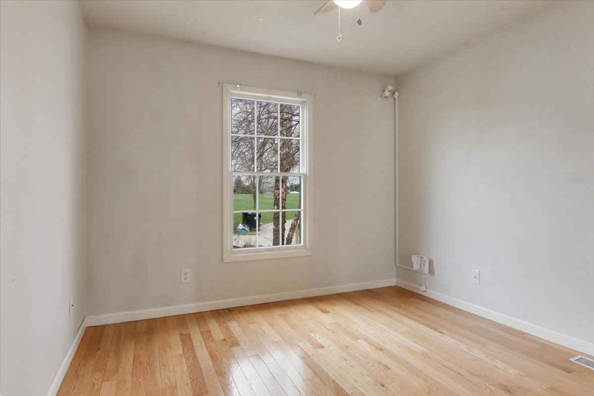 1401 River Landing Street Normal, IL 61761 - Photo 10 of 27 an empty room with wooden floor cabinet and windows