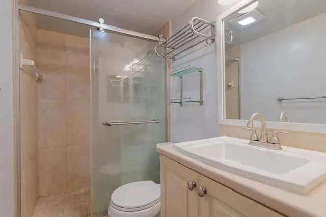 a bathroom with a sink a toilet and shower