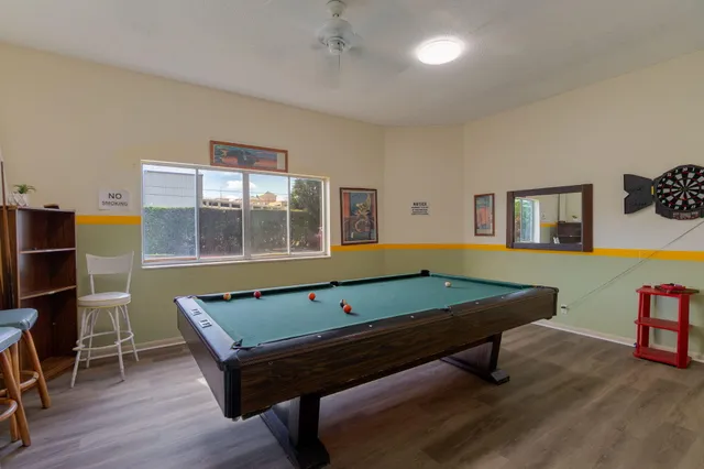 a room with furniture pool table and wooden floor