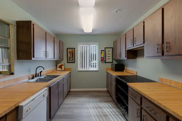 a kitchen with granite countertop a sink stove top oven and cabinets