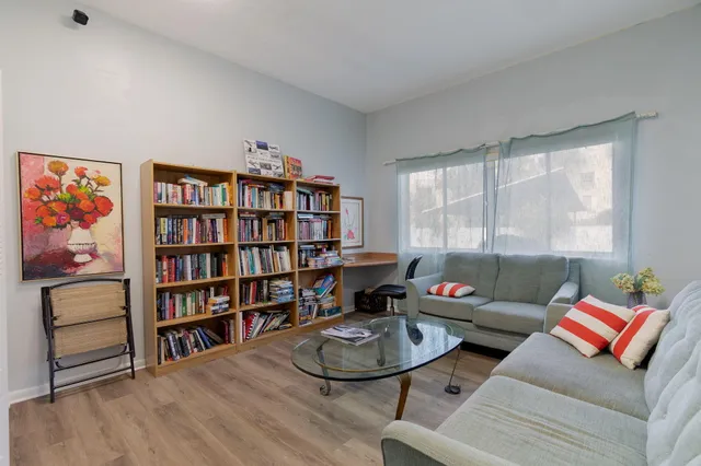 a living room with furniture and a book shelf