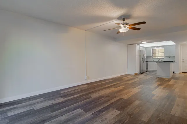 a view of empty room with wooden floor and window