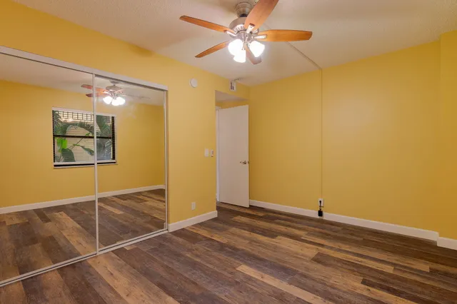a view of a room with wooden floor and a ceiling fan