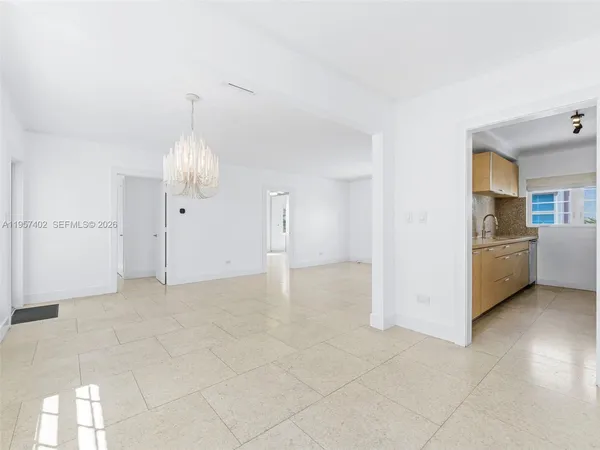 a view of a kitchen with furniture and an empty room