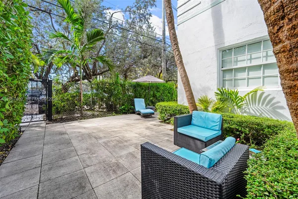a palm tree sitting in front of a house with palm trees
