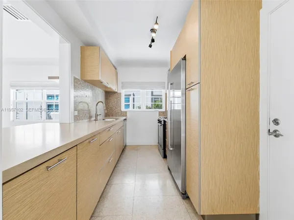 a view of a kitchen with a sink and refrigerator