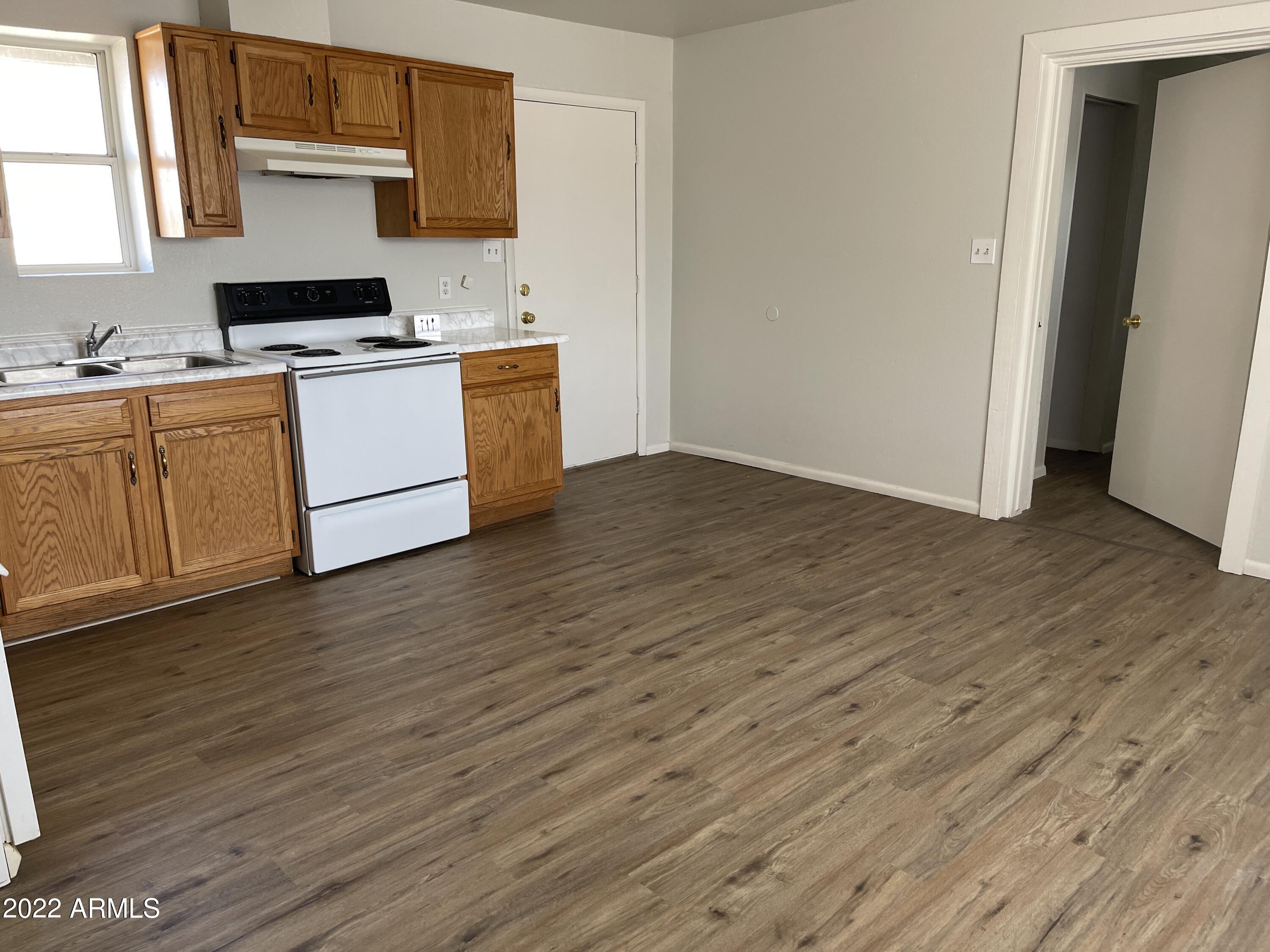 1504 North French Street, Unit B Casa Grande, AZ 85122 - Photo 12 of 23 a kitchen with wooden floors and white cabinets