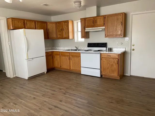 a kitchen with a refrigerator and a stove top oven