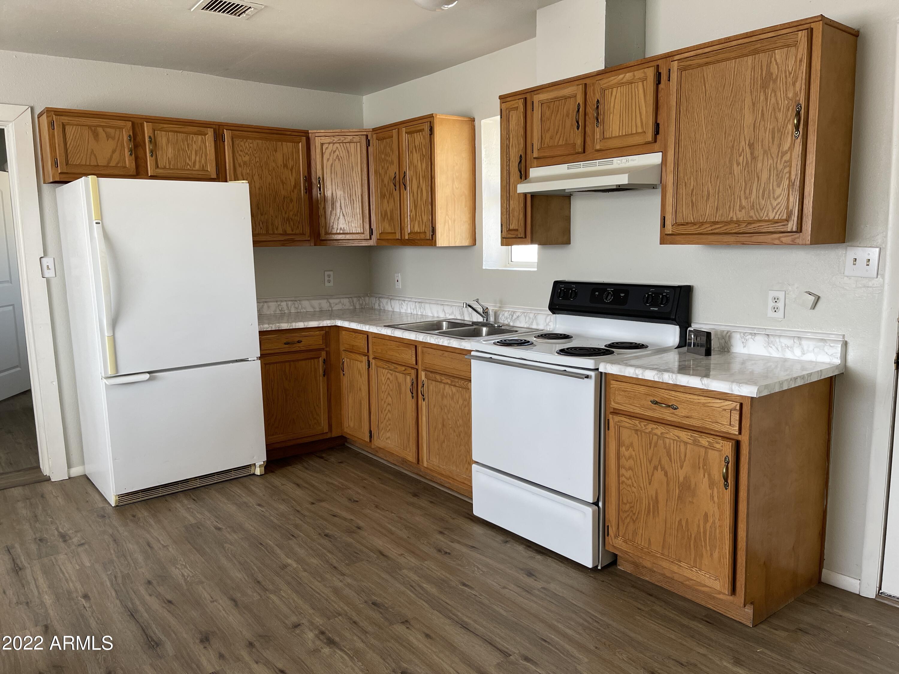 1504 North French Street, Unit B Casa Grande, AZ 85122 - Photo 14 of 23 a kitchen with stainless steel appliances white cabinets and wooden floor