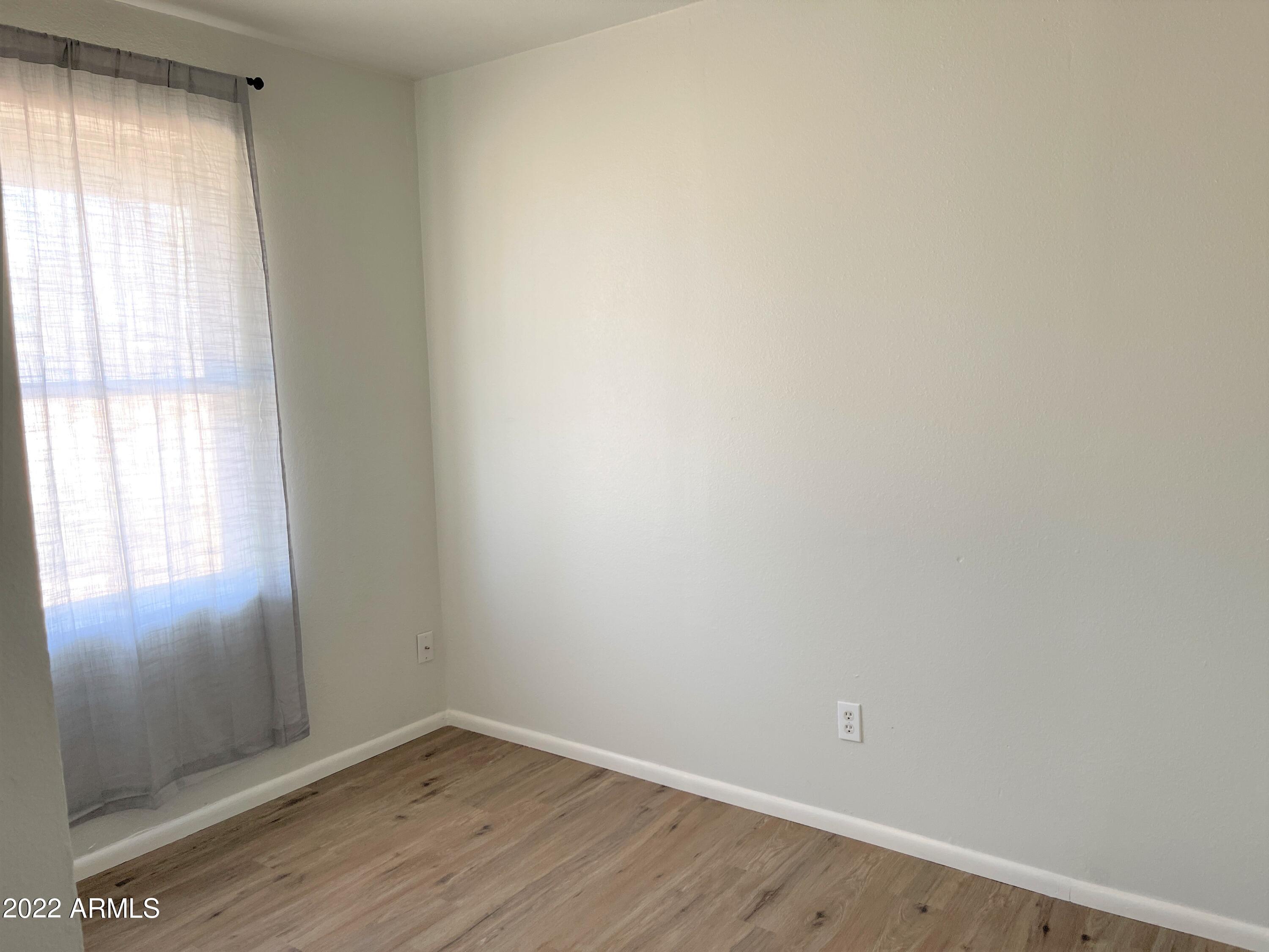 1504 North French Street, Unit B Casa Grande, AZ 85122 - Photo 18 of 23 an empty room with wooden floor and windows
