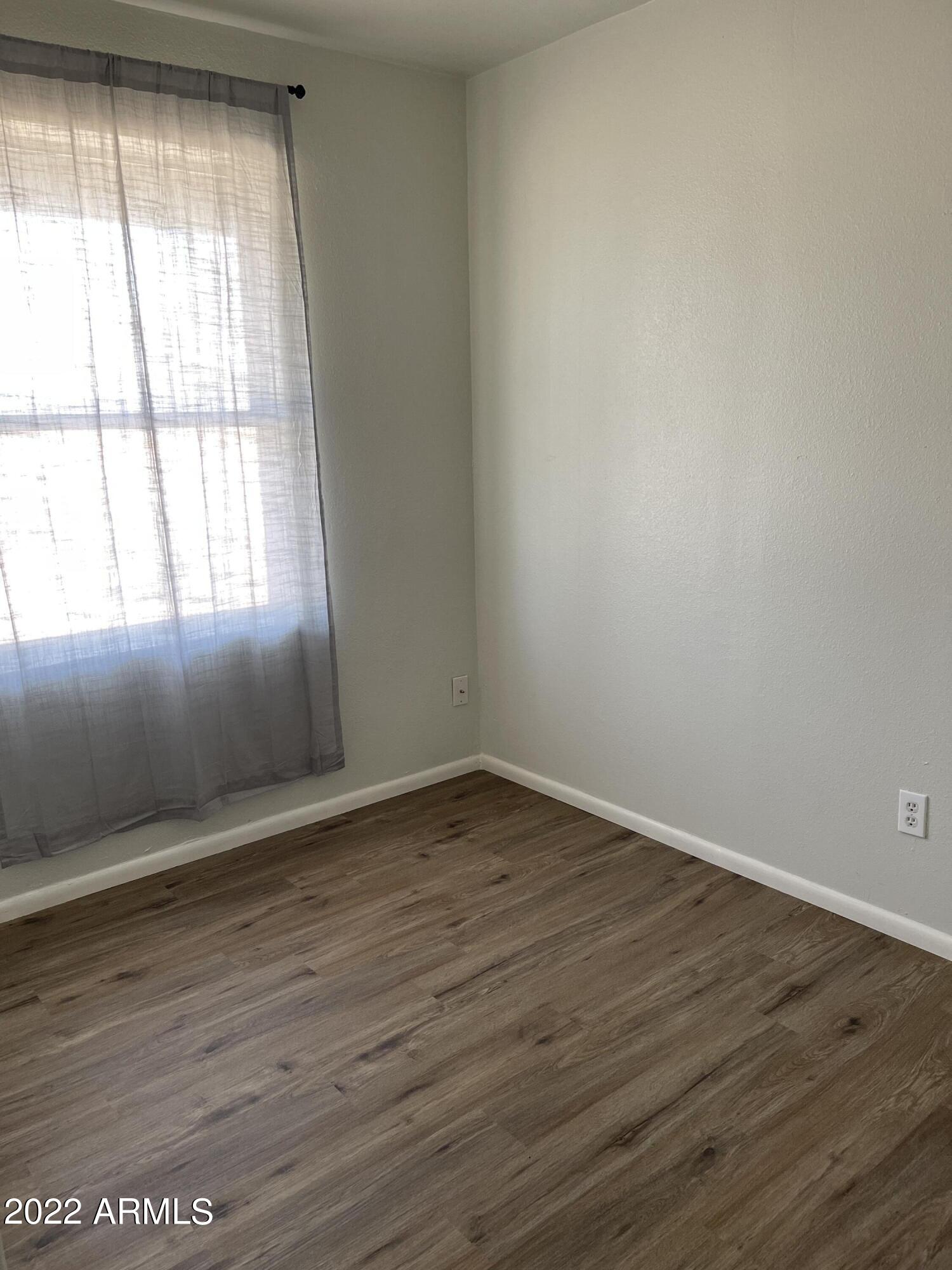 1504 North French Street, Unit B Casa Grande, AZ 85122 - Photo 7 of 23 an empty room with wooden floor and windows