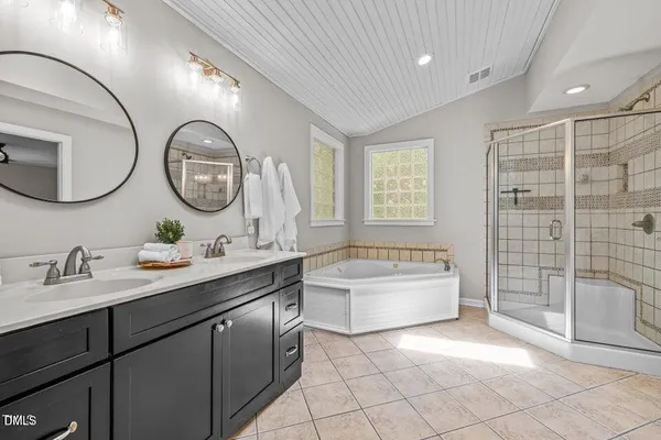 a bathroom with a tub sink and mirror