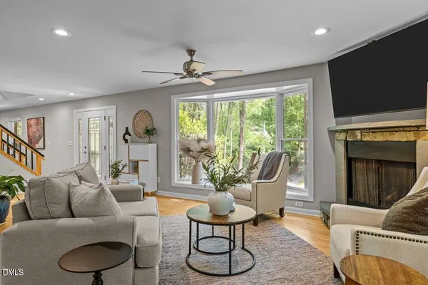 a living room with furniture a flat screen tv and a large window