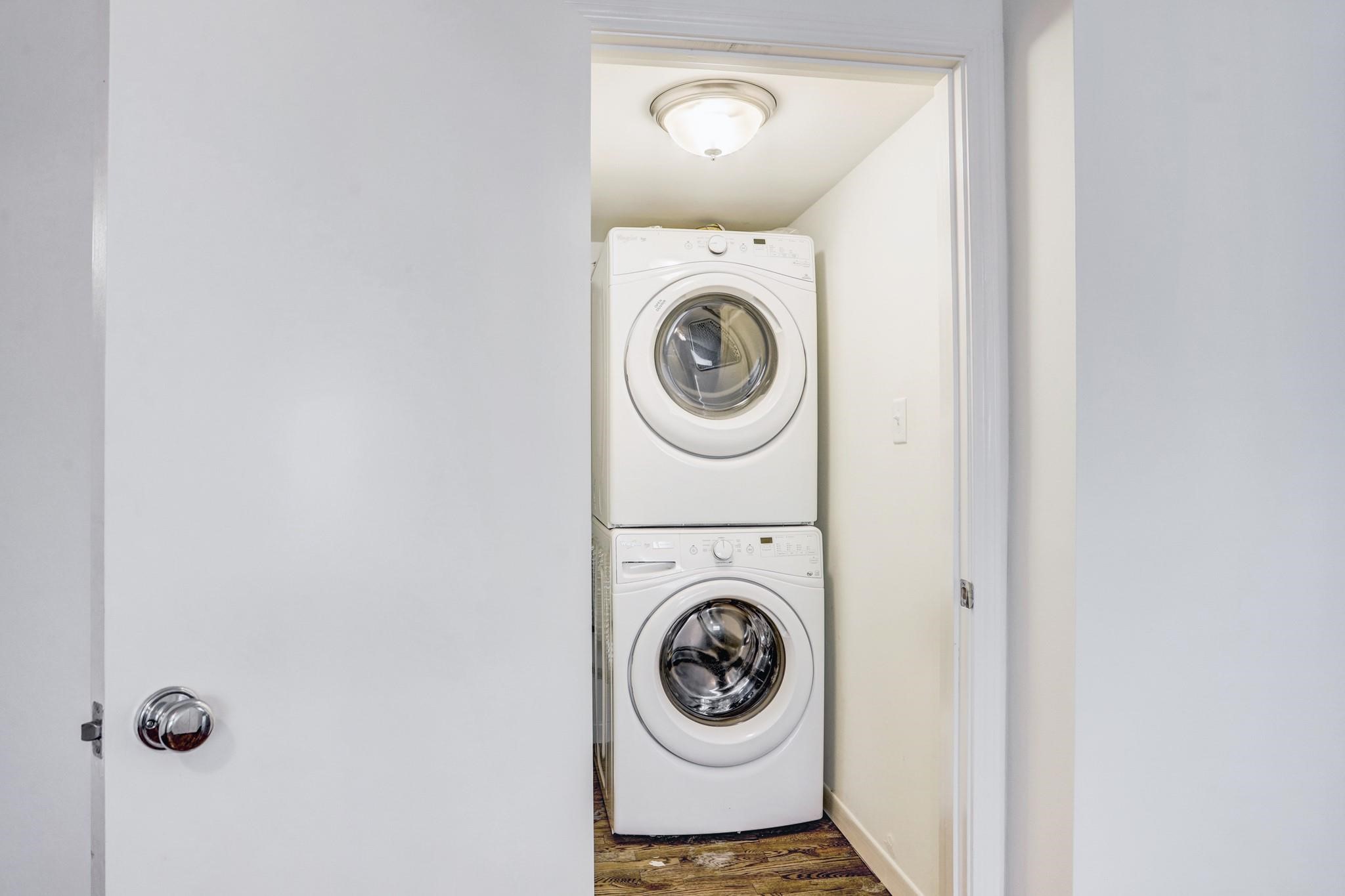 415 Hawthorne Street, Unit 4 Houston, TX 77006 - Photo 7 of 7 Full laundry area with a stacked washer and dryer, neatly tucked into a small, well-lit closet.