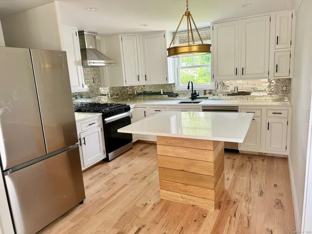 a kitchen with granite countertop white cabinets and white appliances