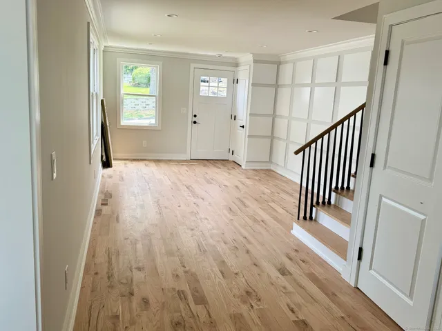 a view of a hallway with wooden floor and stairs