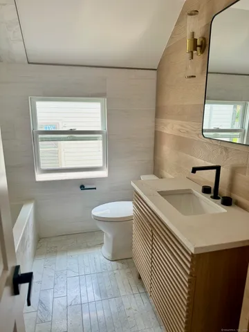 a bathroom with a sink toilet and window