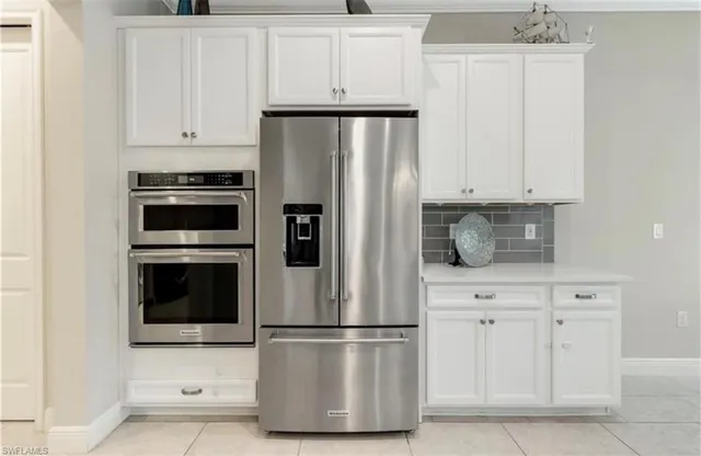 a white refrigerator freezer and a stove sitting inside of a kitchen