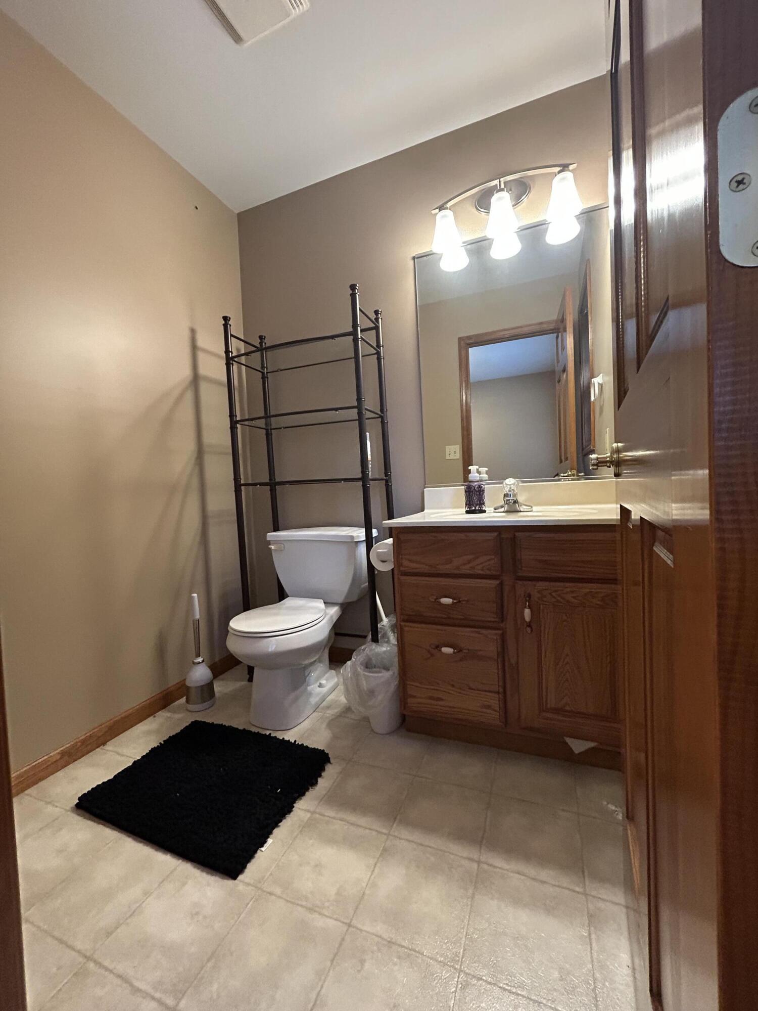 8876 North Lilac Street Demotte, IN 46310 - Photo 22 of 23 a bathroom with a sink a toilet a mirror and vanity