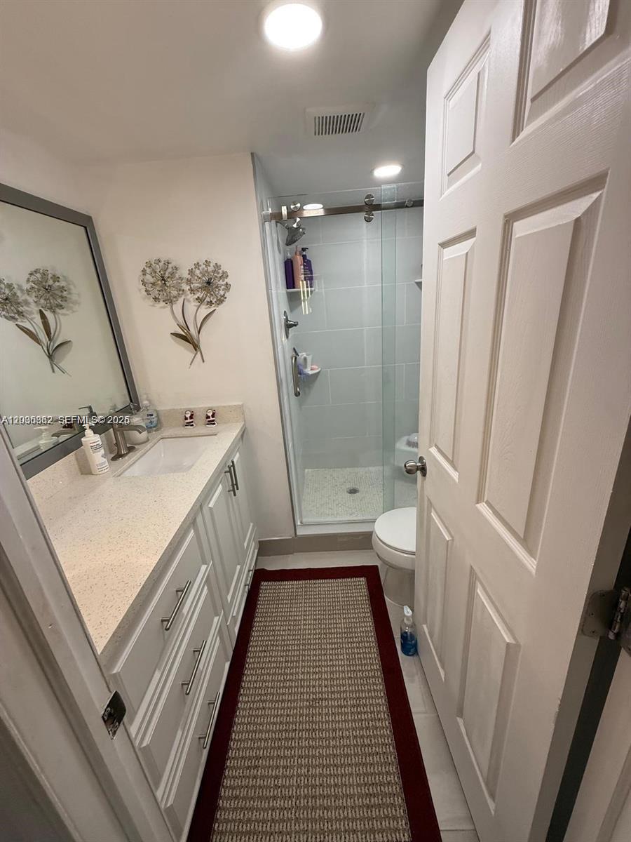 2900 North Pine Island Road, Unit 209 Sunrise, FL 33322 - Photo 11 of 14 a bathroom with a sink a toilet a mirror and shower