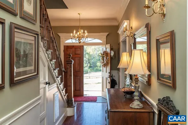 a view of a dining room with furniture a chandelier and wooden floor